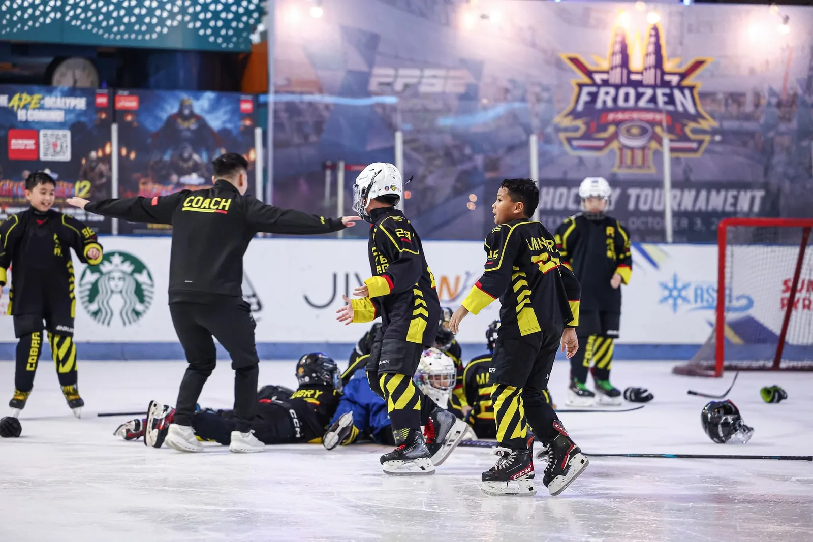A Golden Cobras coach running to celebrate with his U11 players on the ice at Frozen Faceoff 2026